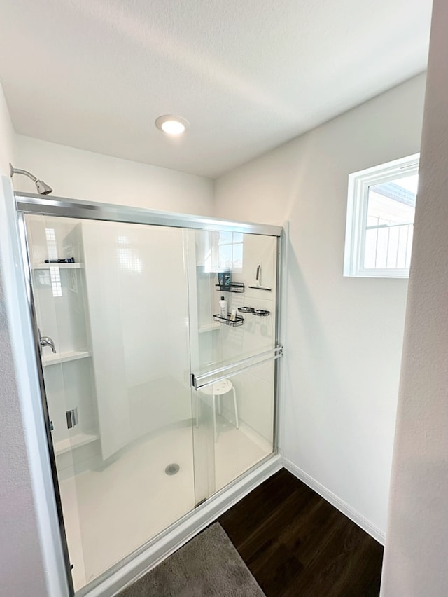 bathroom with walk in shower and wood-type flooring