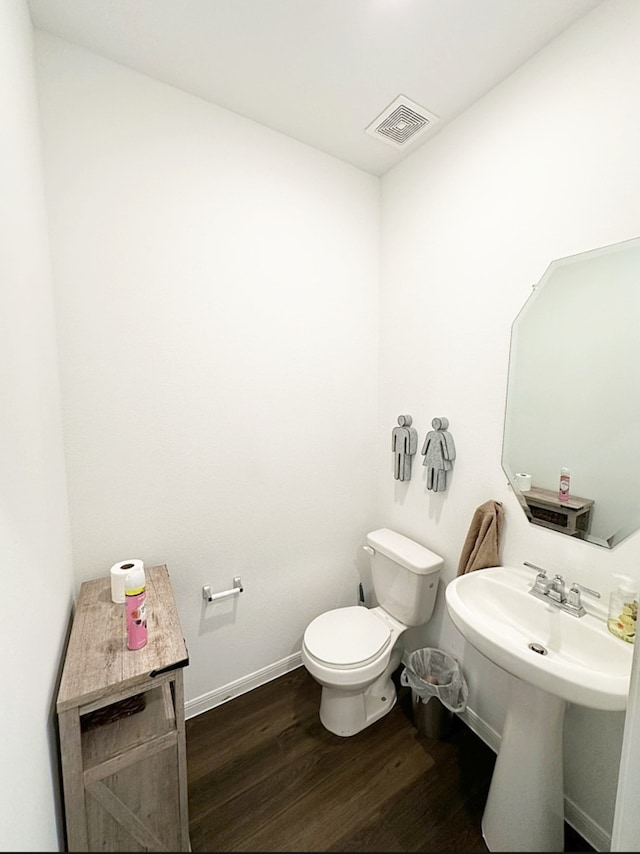 bathroom with toilet and wood-type flooring