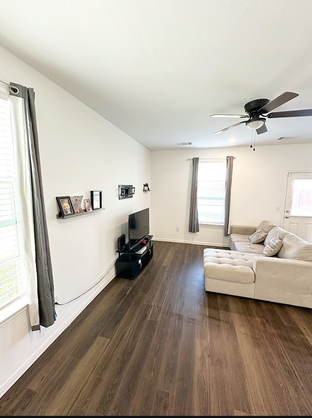 unfurnished living room with dark wood-type flooring and ceiling fan