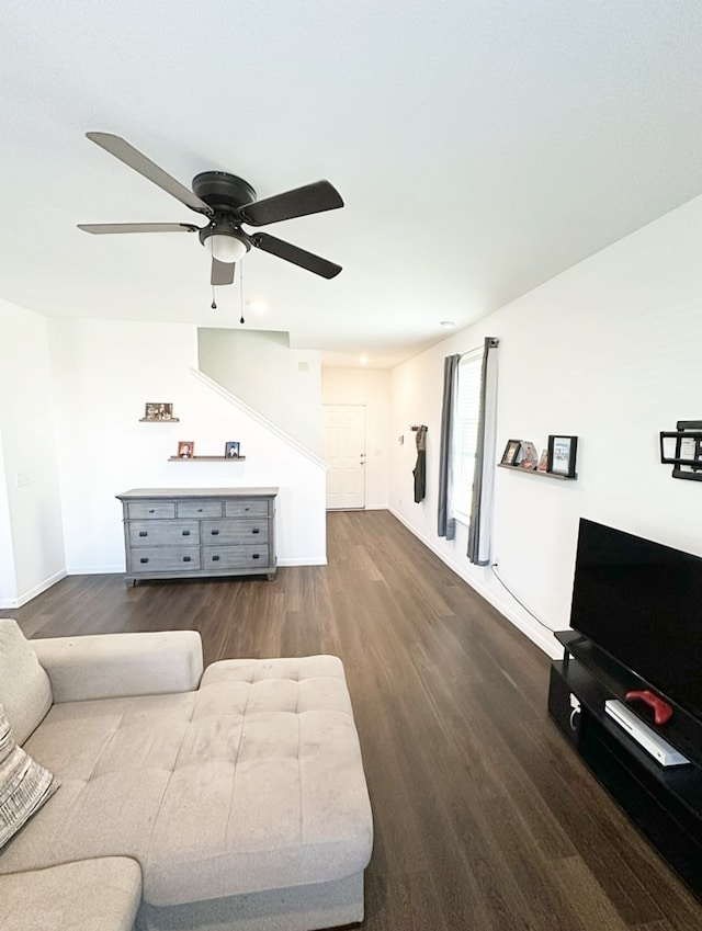 living room with dark wood-type flooring and ceiling fan