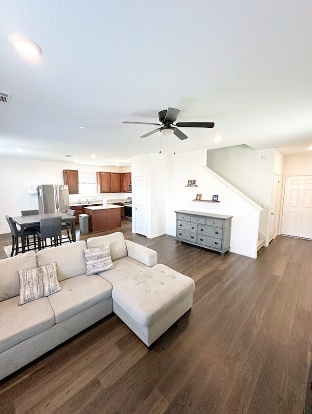 living room with dark wood-type flooring and ceiling fan