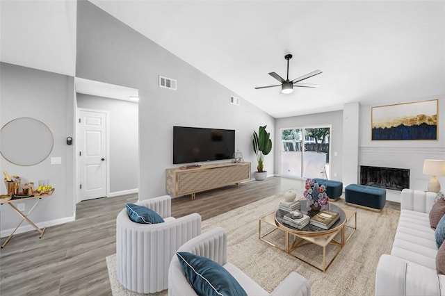 living room featuring hardwood / wood-style flooring, ceiling fan, and high vaulted ceiling