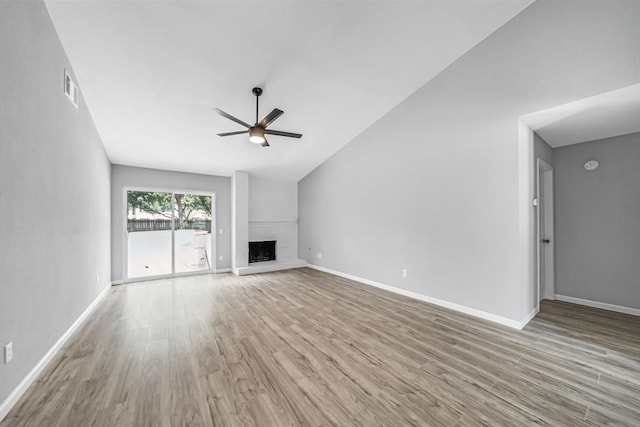 unfurnished living room featuring high vaulted ceiling, light wood-type flooring, ceiling fan, and a fireplace