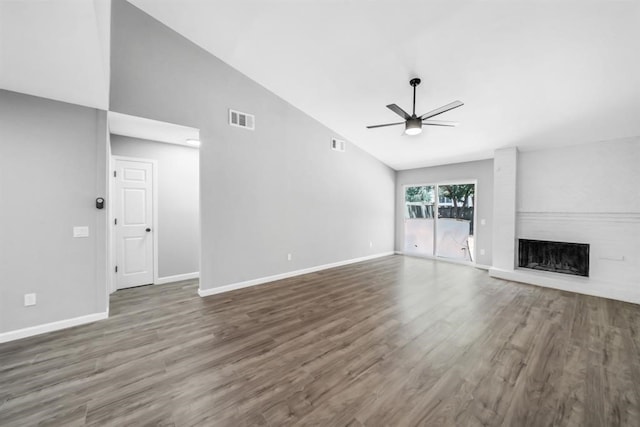 unfurnished living room featuring a brick fireplace, ceiling fan, high vaulted ceiling, and dark hardwood / wood-style flooring