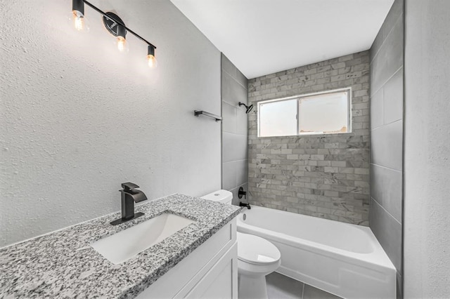 full bathroom featuring toilet, tiled shower / bath combo, vanity, and tile patterned flooring