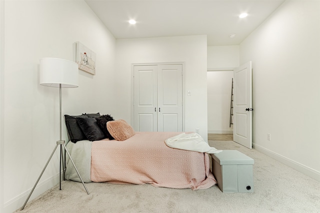 bedroom with a closet and light carpet