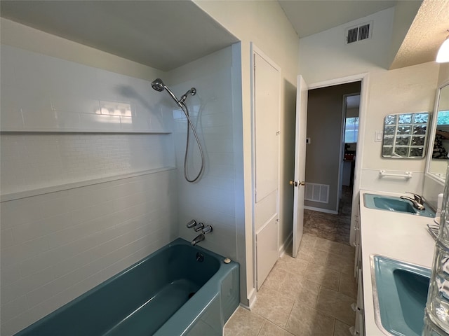 bathroom with tile patterned flooring, vanity, and tiled shower / bath combo