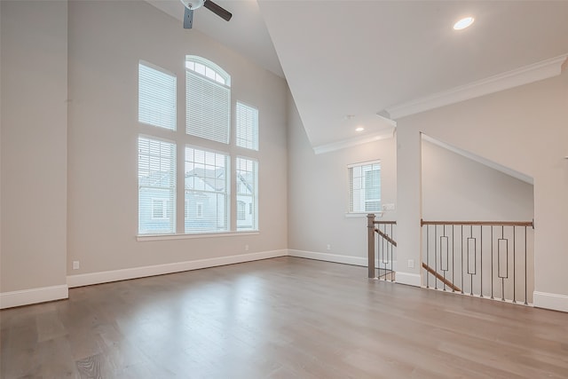 interior space with wood-type flooring, ceiling fan, and a high ceiling