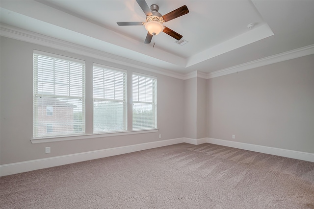 carpeted spare room featuring ornamental molding, ceiling fan, and a raised ceiling