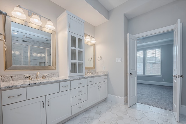 bathroom with a shower with shower door and vanity