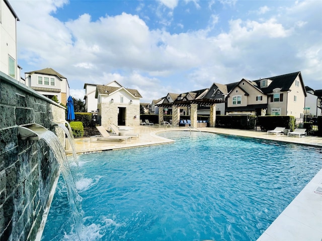 view of pool with a patio, a pergola, and pool water feature