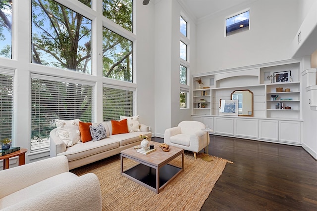 living room featuring a high ceiling, dark hardwood / wood-style flooring, and ornamental molding