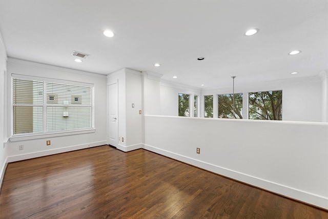 empty room with dark hardwood / wood-style floors and crown molding