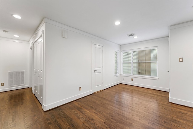 unfurnished room featuring ornamental molding and dark hardwood / wood-style floors