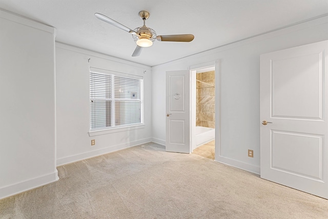 unfurnished bedroom with crown molding, light carpet, ceiling fan, and ensuite bath