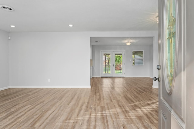 unfurnished room with light wood-type flooring and french doors