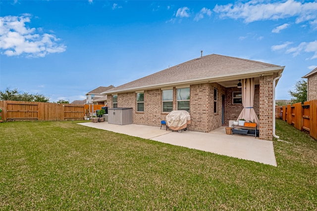 back of house with a lawn and a patio