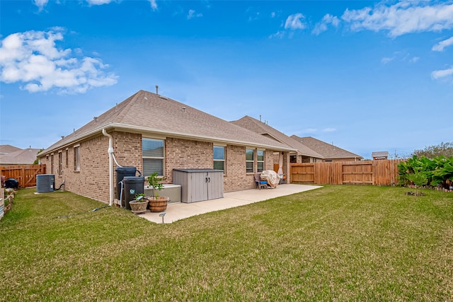 rear view of house with central AC, a yard, and a patio area