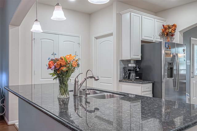 kitchen featuring white cabinetry, sink, dark stone counters, stainless steel fridge with ice dispenser, and pendant lighting