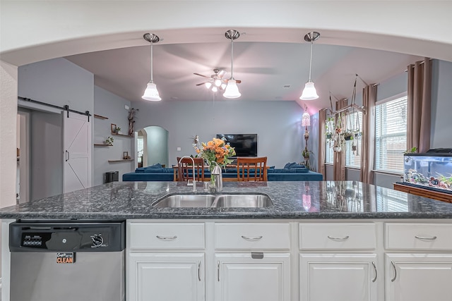 kitchen with a barn door, pendant lighting, sink, white cabinets, and dishwasher