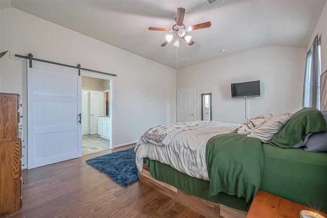 bedroom with ensuite bathroom, ceiling fan, wood-type flooring, lofted ceiling, and a barn door