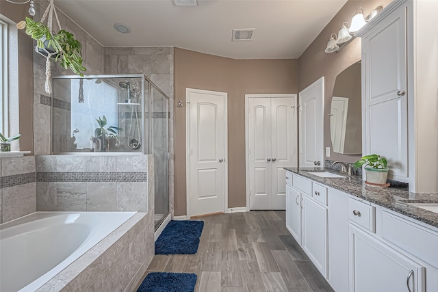 bathroom with shower with separate bathtub, vanity, and hardwood / wood-style flooring