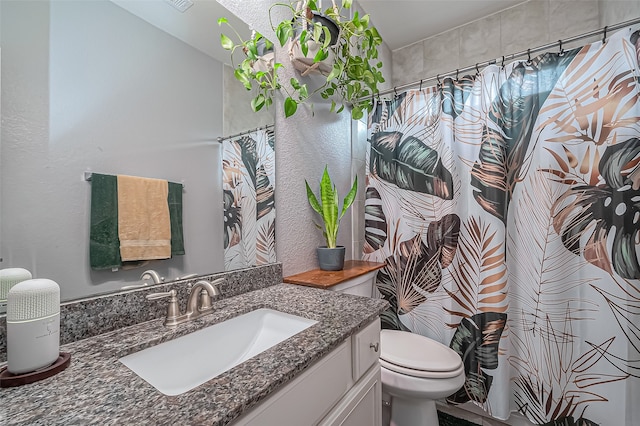 bathroom with toilet, vanity, and curtained shower