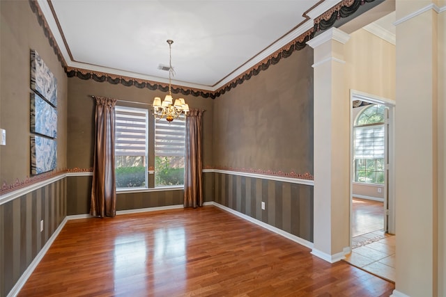 unfurnished dining area with hardwood / wood-style flooring, a notable chandelier, and ornamental molding