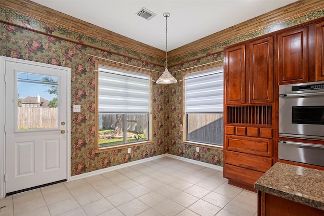 kitchen with stainless steel oven, light tile patterned floors, hanging light fixtures, and dark stone counters