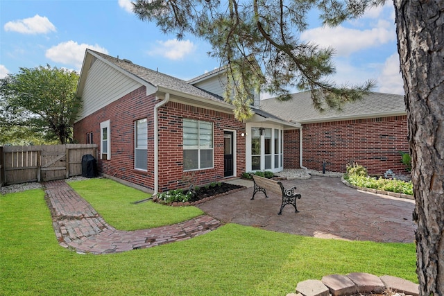 rear view of house with a lawn and a patio area