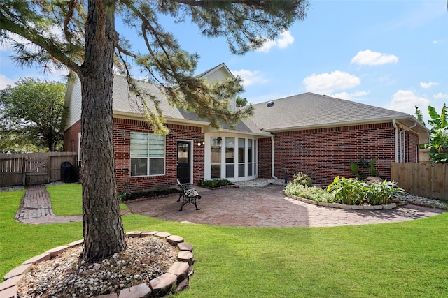 back of property with a patio area and a lawn