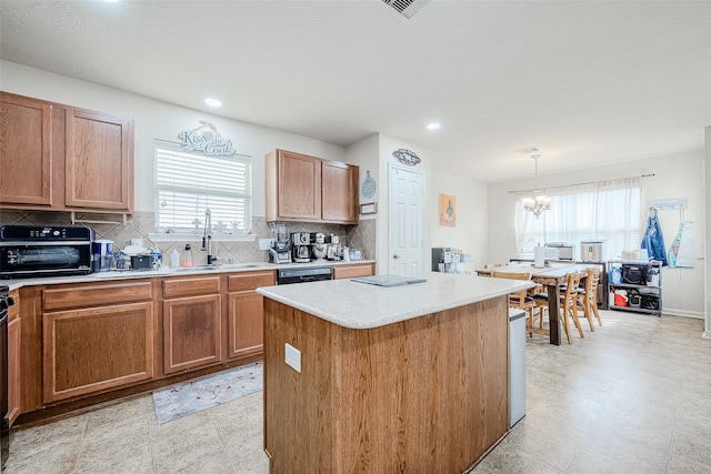 kitchen with backsplash, a wealth of natural light, sink, and a center island