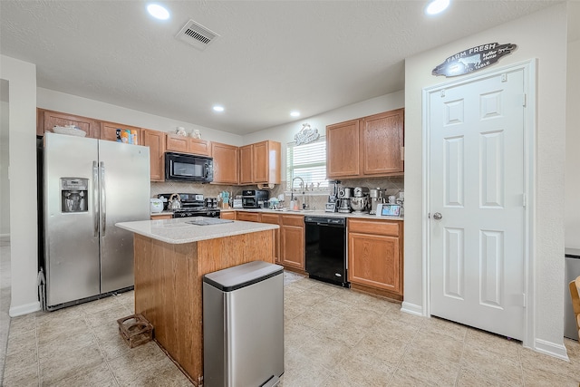 kitchen with black appliances, a kitchen island, sink, and decorative backsplash