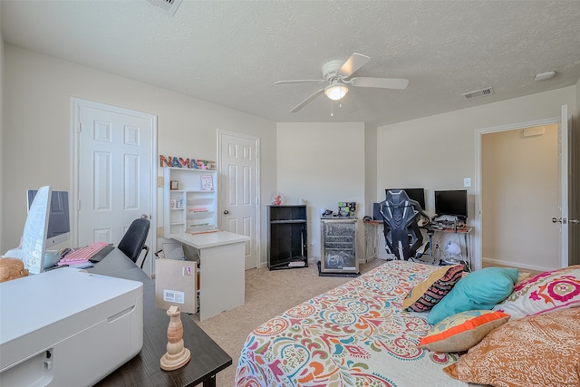 carpeted bedroom featuring a textured ceiling and ceiling fan