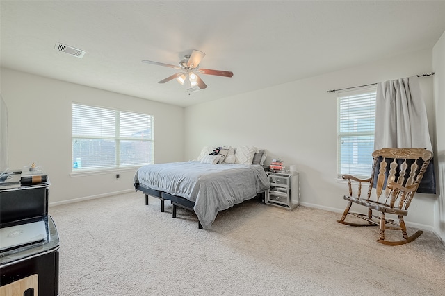 carpeted bedroom with ceiling fan and multiple windows