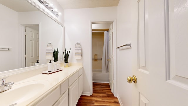 bathroom featuring wood-type flooring, vanity, and shower / bath combination with curtain