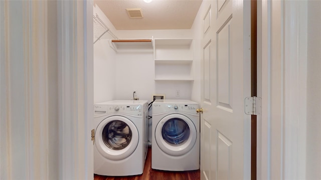 laundry area with dark hardwood / wood-style flooring, washer and clothes dryer, and a textured ceiling