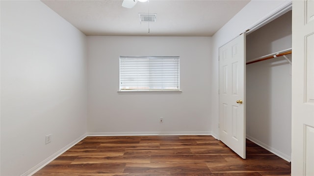 unfurnished bedroom with ceiling fan, dark hardwood / wood-style flooring, and a closet