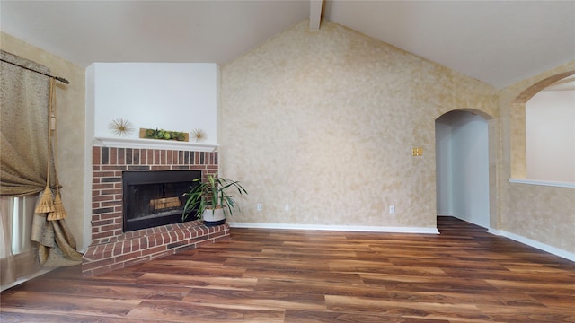 unfurnished living room with a fireplace, lofted ceiling with beams, and dark hardwood / wood-style floors