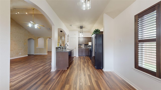 kitchen featuring ceiling fan, sink, dark hardwood / wood-style floors, vaulted ceiling, and fridge