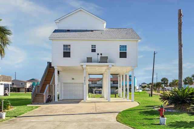 view of front of home featuring central air condition unit, a carport, a front yard, and a garage