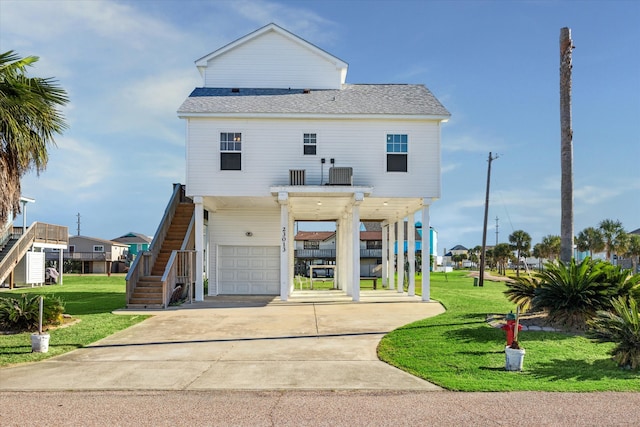 view of front of property with a front lawn, central AC unit, and a garage