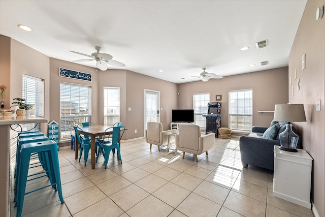 tiled living room featuring ceiling fan and a wealth of natural light