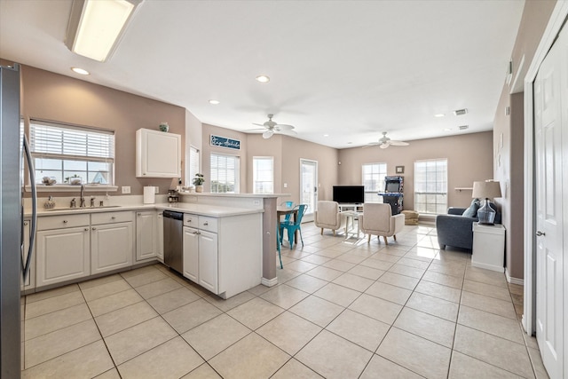 kitchen featuring stainless steel appliances, white cabinetry, and plenty of natural light