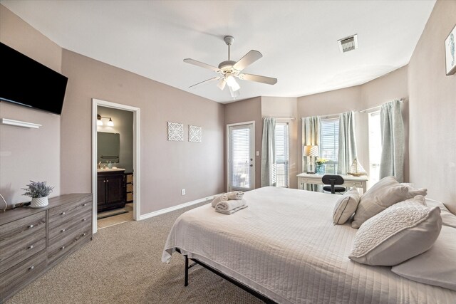 bedroom with ceiling fan, ensuite bathroom, and light carpet