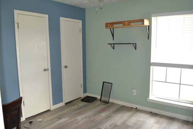 empty room with light wood-type flooring, a textured ceiling, and ceiling fan