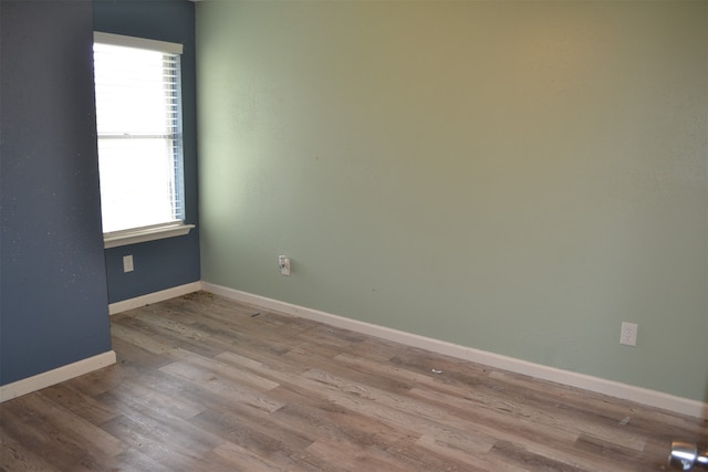 empty room with light hardwood / wood-style floors and a healthy amount of sunlight