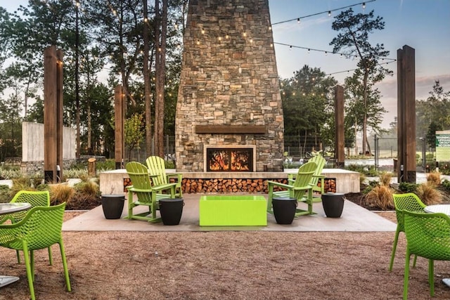 patio terrace at dusk with an outdoor stone fireplace