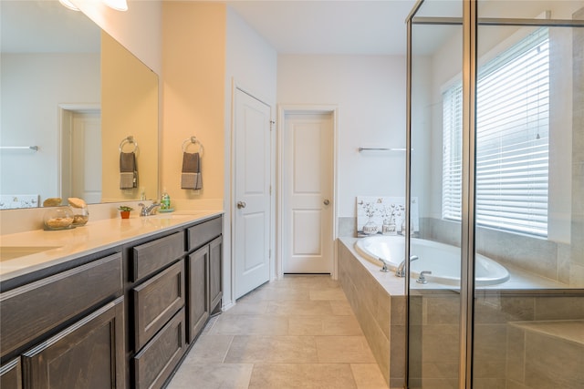 bathroom with vanity, a relaxing tiled tub, and tile patterned floors