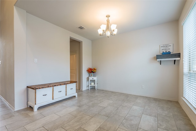 empty room featuring an inviting chandelier